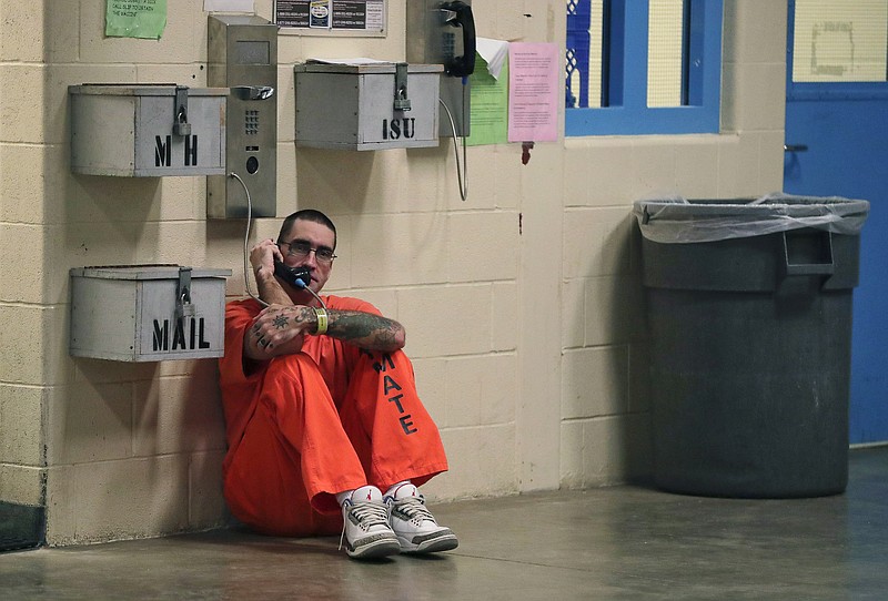 FILE - In this Nov. 27, 2017 file photo, inmate Lance Shaver talks on the phone at the Albany County Correctional Facility in Albany, N.Y. Connecticut is considering legislation which would make phone calls from prison free to inmates. (AP Photo/Julie Jacobson, File)