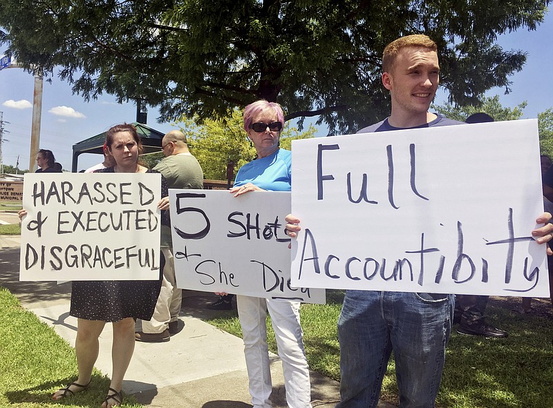 From left, Felicia Young, 28, Susan Cummings, 61, and Bryon Cummings, 22, demonstrate outside Baytown Police Department in Baytown, Texas, Tuesday, May 14, 2019. A Texas police officer fatally shot a woman who police said grabbed his Taser and used it against him, moments after she seemed to say "I'm pregnant" in an altercation captured on video. (AP Photo/John L. Mone)