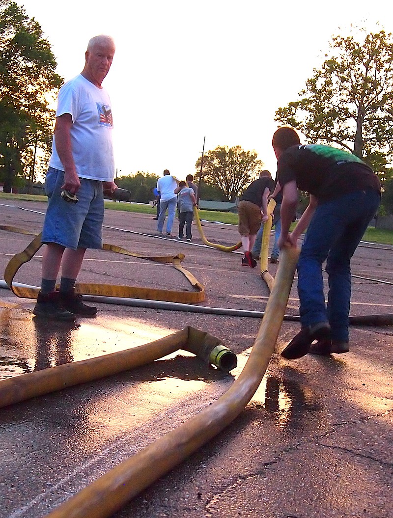 A fire department's hoses can look like big snakes. Helping firefighter James Ragsdale, left, stretch the hose is Kendall Collins with fire cadets Dylan Noble, Cameron Hardin and Asa Revey.