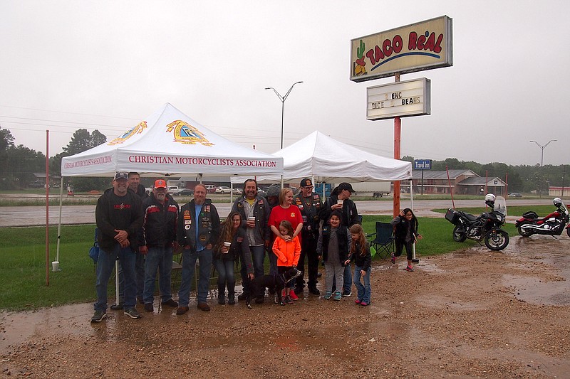 The Christian Motorcyclists Association group poses outside its tent showing they aren't afraid of getting a little wet Saturday. It rained but motorcycle riders and supporters turn out for the Atlanta Mudslingers' Coffee and Chrome Motorcycle Awareness ride-in.