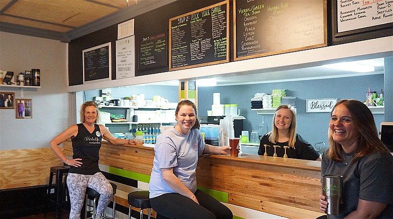 Customer Miranda Champion, center, has stopped by Fit Family Nutrition for her Skittles' tea drink with a shake to follow. Serving her with smiles are owner Katye Birdsong, left, Kali Rushing and Joy Johnson. 