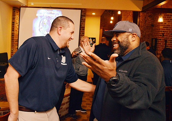 Lincoln head football coach Steven Smith (right) and defensive coordinator Phil Pitts talk during a get together with other coaches and fans during a function to talk about recruiting in 2018. Smith and Pitts have both stepped down from their positions with the program.