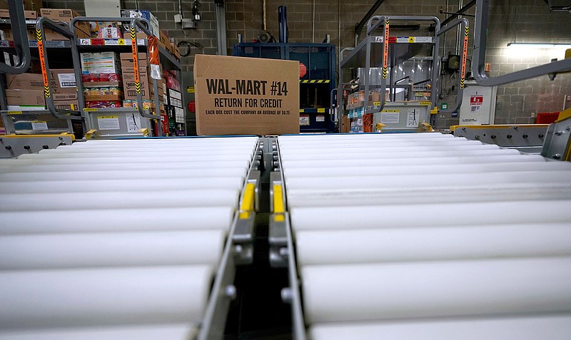 In this Nov. 9, 2018, file photo a box of merchandise is unloaded from a truck and sent along a conveyor belt at a Walmart Supercenter in Houston. Walmart is rolling out free next-day delivery on its most popular items, increasing the stakes in the retail shipping wars with Amazon. The nation's largest retailer said Tuesday it's been building a network of more efficient e-commerce distribution centers to make that happen. (AP Photo/David J. Phillip, File)