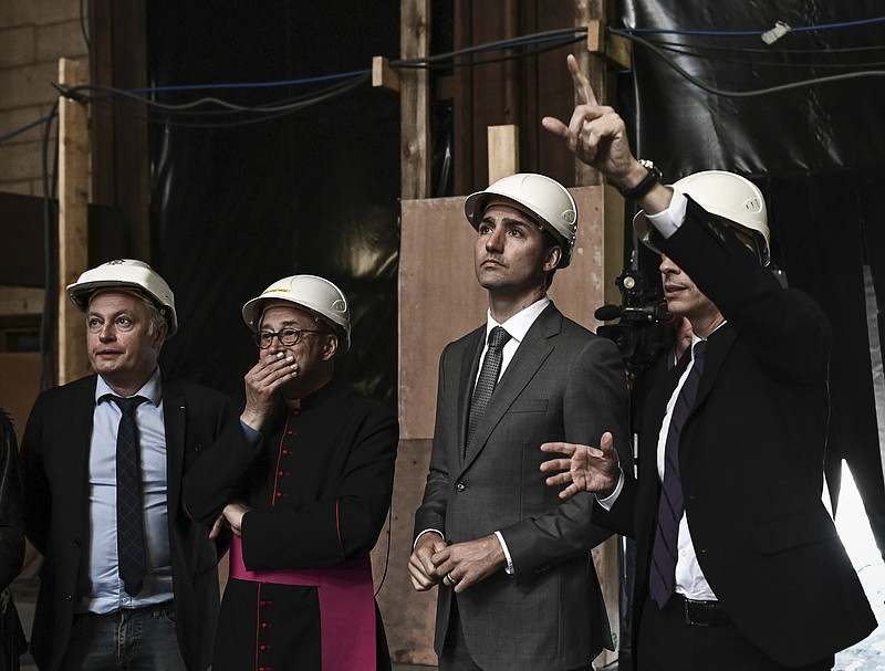 Canadian Prime Minister Justin Trudeau, third left, French Culture Minister Franck Riester, right, Notre Dame cathedral rector Patrick Chauvet, second left, and French chief architect of Historical Sites Philippe Villeneuve visit the Notre Dame de Paris cathedral, Wednesday May 15, 2019 in Paris. (Philippe Lopez/Pool via AP)