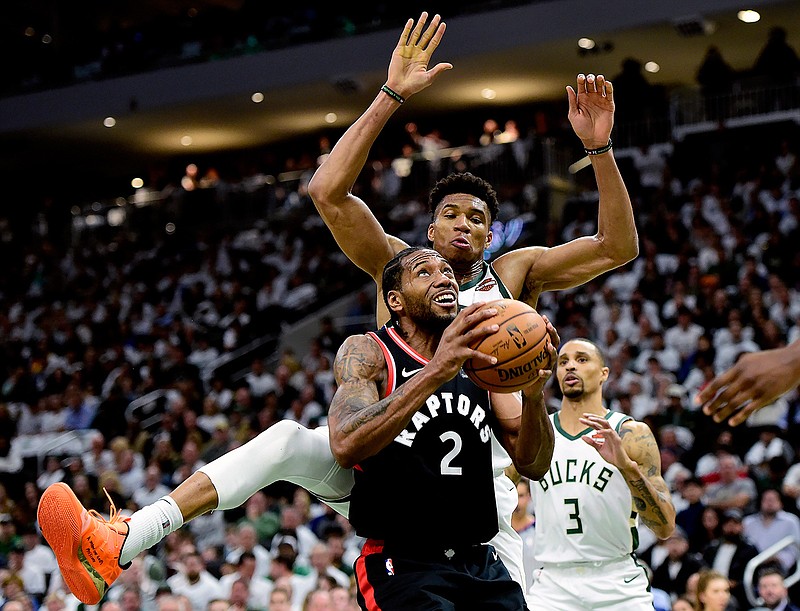 Toronto Raptors forward Kawhi Leonard (2) gets fouled by Milwaukee Bucks forward Giannis Antetokounmpo (34) during the second half in Game 1 of the NBA basketball playoffs Eastern Conference final in Milwaukee on Wednesday, May 15, 2019. (Frank Gunn/The Canadian Press via AP)