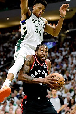 Kawhi Leonard of the Raptors is fouled by Giannis Antetokounmpo of the Bucks during Wednesday night's game  in Milwaukee.