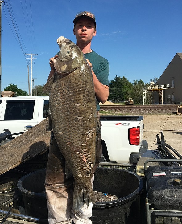 Joshua Lee, of Bernie, shows off his state-record 76-pound black buffalo shot while bowfishing at Duck Creek Conservation Area on April 21, 2019.
