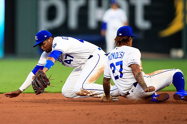 Royals third baseman Kelvin Gutierrez (47) and shortstop Adalberto Mondesi (27) dive for a ball hit by Willie Calhoun of the Rangers during the third inning of Wednesday night's game at Kauffman Stadium in Kansas City.