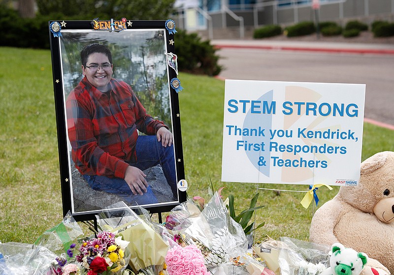 A photograph of student Kendrick Castillo stands amid a display of tributes outside the STEM School Highlands Ranch a week after the attack on the school that left Castillo dead and others injured, Tuesday, May 14, 2019, in Highlands Ranch, Colo. (AP Photo/David Zalubowski)