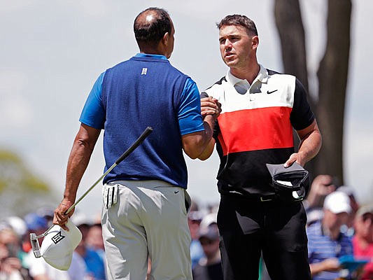 Brooks Koepka shakes hands with Tiger Woods after finishing Thursday's first round of the PGA Championship at Bethpage Black in Farmingdale, N.Y.