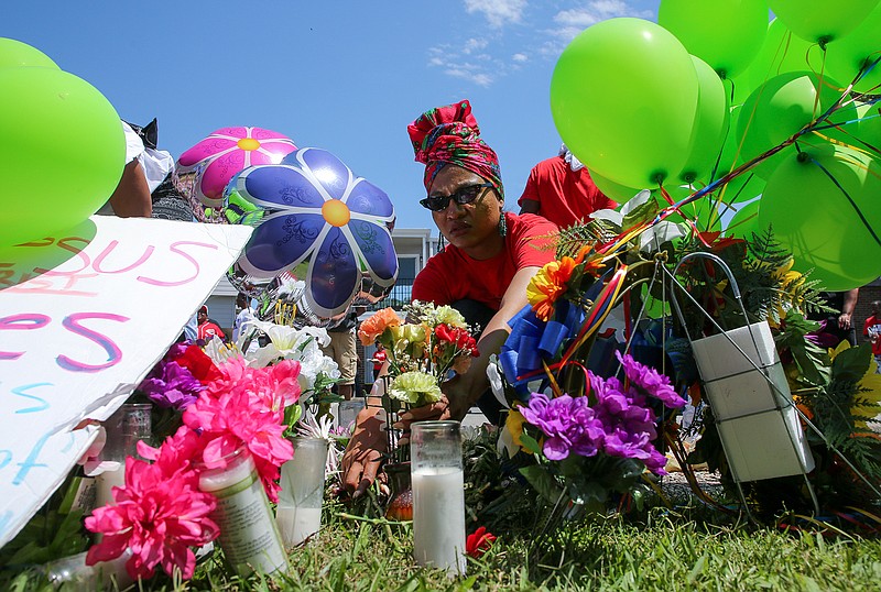 Ahsaki Chachere arranges flowers Wednesday, May 15, 2019, at the memorial for Pamela Turner, who was killed Monday night during a confrontation with a Baytown Police officer at The Brixton Apartments complex in Baytown, Texas. (Godofredo A Vasquez/Houston Chronicle via AP)/Houston Chronicle via AP)