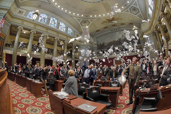 Members of the Missouri House of Representatives toss papers Friday at the conclusion of the 100th General Assembly.