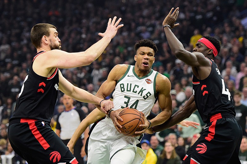 Milwaukee Bucks forward Giannis Antetokounmpo (34) drives between Toronto Raptors center Marc Gasol, left, and forward Pascal Siakam during the first half of Game 2 of the NBA basketball playoffs Eastern Conference finals, Friday, May 17, 2019, in Milwaukee. (Frank Gunn/The Canadian Press via AP)