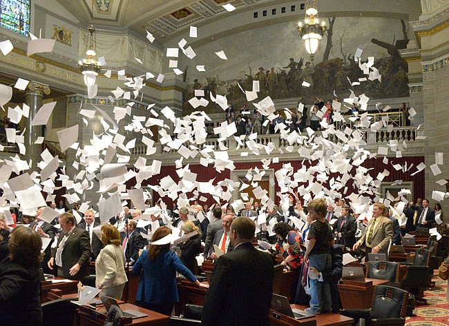 Representatives toss papers in the air Friday during the last day of session. 