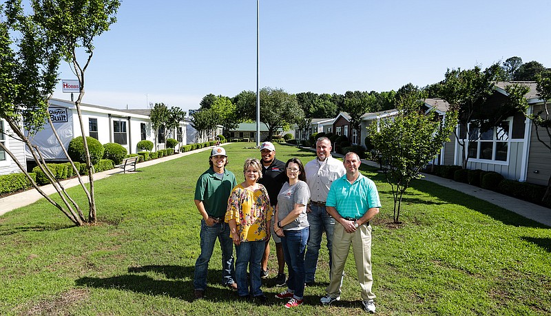 Staff members of Hobbs Manufactured Homes pose for a group portrait in the center of what they call the village in Texarkana, Texas. 