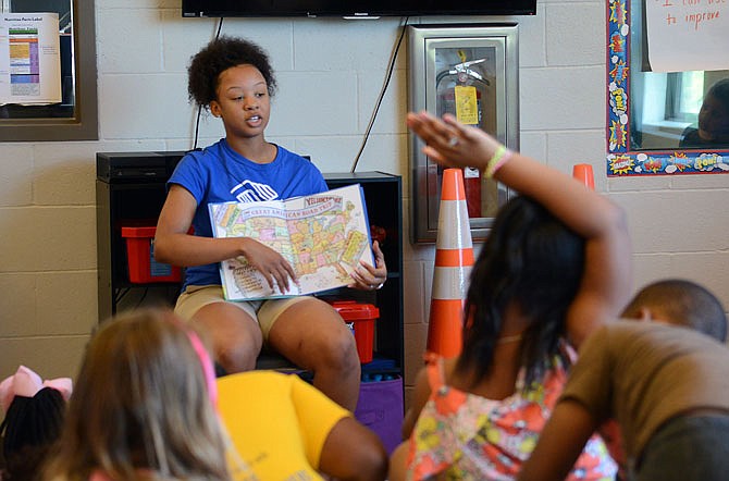 Lincoln University student Keianna Hunter reads a book after school Thursday to first-grade students at the Boys & Girls Club of Jefferson City. The club is one area resource to help families facing poverty. A statewide report says about 19 percent of Missouri children live in poverty.