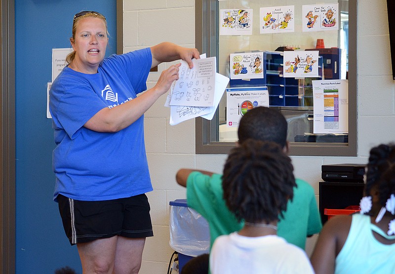 Sally Ince/ News Tribune
Teacher Christina Massman shows children what they will color Thursday May 16, 2019 at the Boys & Girls Club of Jefferson City. Massman is also an employee at East Elementary School.