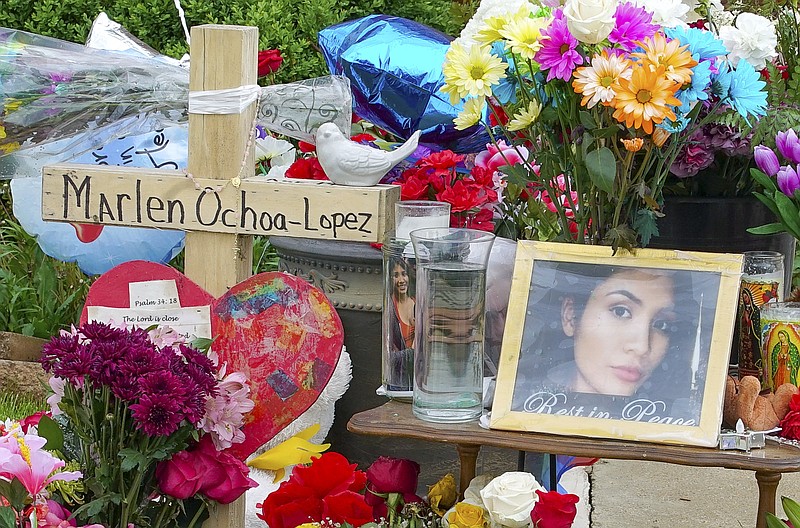 A memorial of flowers, balloons, a cross and photo of victim Marlen Ochoa-Lopez, are displayed on the lawn, Friday, May 17, 2019 in Chicago, outside the home where Ochoa-Lopez was murdered last month. Assistant State's Attorney James Murphy says a pregnant Ochoa-Lopez, who was killed and whose baby was cut from her womb, was strangled while being shown a photo album of the late son and brother of her attackers. (AP Photo/Teresa Crawford)