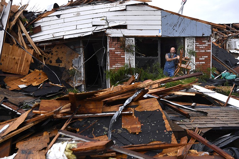 Wesley Mantooth lifts a wooden chair out a window of the home of his father, Robert, in Abilene, Texas, on Saturday, May 18, 2019. Many residents said a tornado struck in the early morning hours. (Ronald W. Erdrich/The Abilene Reporter-News via AP)