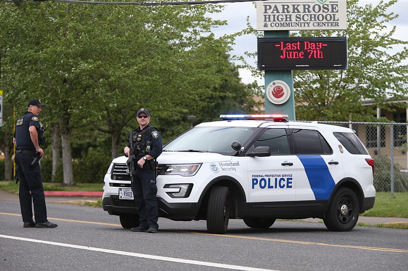 Police are positioned outside Parkrose High School Parkrose High School during a lockdown after a man armed with a gun was wrestled to the ground by a staff member, Friday, May 17, 2019 in Portland, Ore. The Portland Police Bureau said in a statement Friday that no shots were fired at Parkrose High School, no one was injured and the man is in custody. Police say there are no other suspects. (Dave Killen/The Oregonian via AP)