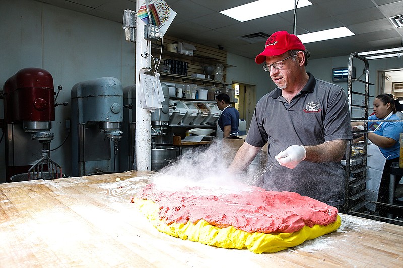 In this Aug. 17, 2018, photo Three Brothers Bakery owner Bobby Jucker throws flour on dough at the South Braeswood Boulevard location in Houston. (Michael Ciaglo/Houston Chronicle via AP)