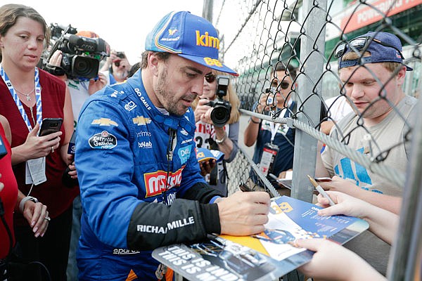 Fernando Alonso stops to sign autographs after qualifications ended Saturday for the Indianapolis 500 at Indianapolis Motor Speedway in Indianapolis.