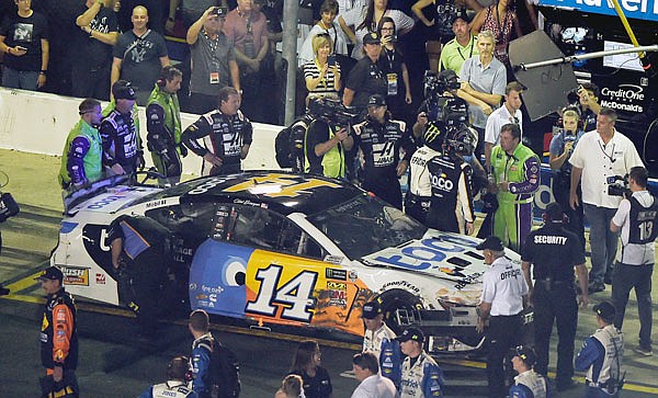 (At right) A NASCAR official tries to get between drivers Ryan Newman (in green suit) and Clint Bowyer after Saturday night's All-Star Race in Concord, N.C.