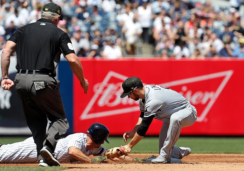 New York Yankees' Brett Gardner dives back safely avoiding the tag from Tampa Bay Rays second baseman Brandon Lowe on a pick off attempt as umpire Ted Barrett watches the play during the third inning of a baseball game, Saturday, May 18, 2019, in New York. (AP Photo/Jim McIsaac)