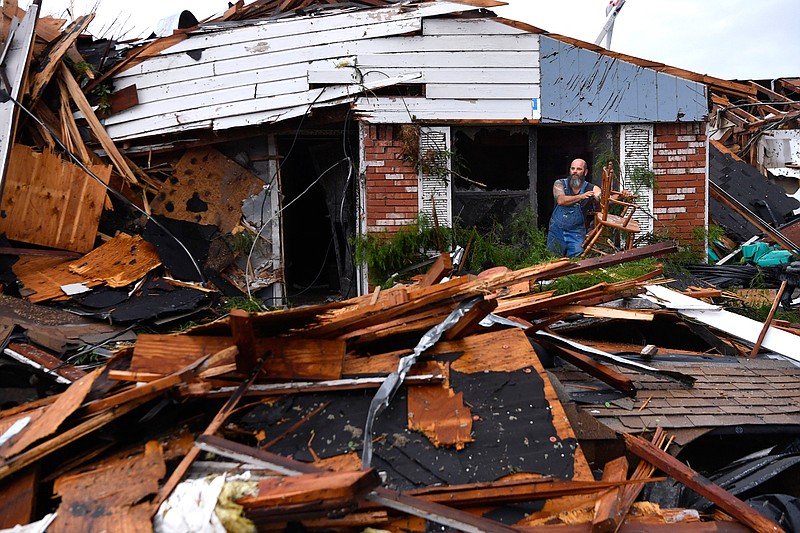 Wesley Mantooth lifts a wooden chair out a window of the home of his father, Robert, in Abilene, Texas, on Saturday, May 18, 2019. Many residents said a tornado struck in the early morning hours. (Ronald W. Erdrich/The Abilene Reporter-News via AP)