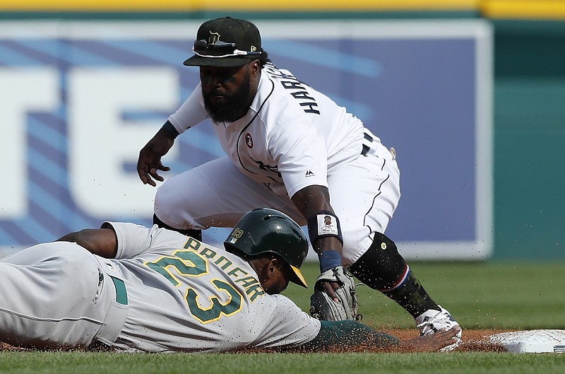 Oakland Athletics' Jurickson Profar (23) beats the pickoff attempt to Detroit Tigers second baseman Josh Harrison (1) during the fifth inning of a baseball game, Saturday, May 18, 2019, in Detroit. (AP Photo/Carlos Osorio)