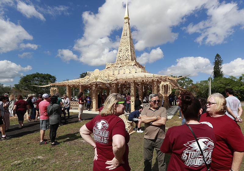 FILE - In this Feb. 14, 2019, file photo, people gather around the "Temple of Time" in honor of the 17 that were killed during the Marjory Stoneman Douglas High School shooting in 2018 in Coral Springs, Fla. The temple built as a memorial to the 17 victims of a Florida high school mass shooting is to be burned to the ground in a symbolic gesture of healing. (AP Photo/Wilfredo Lee, File)