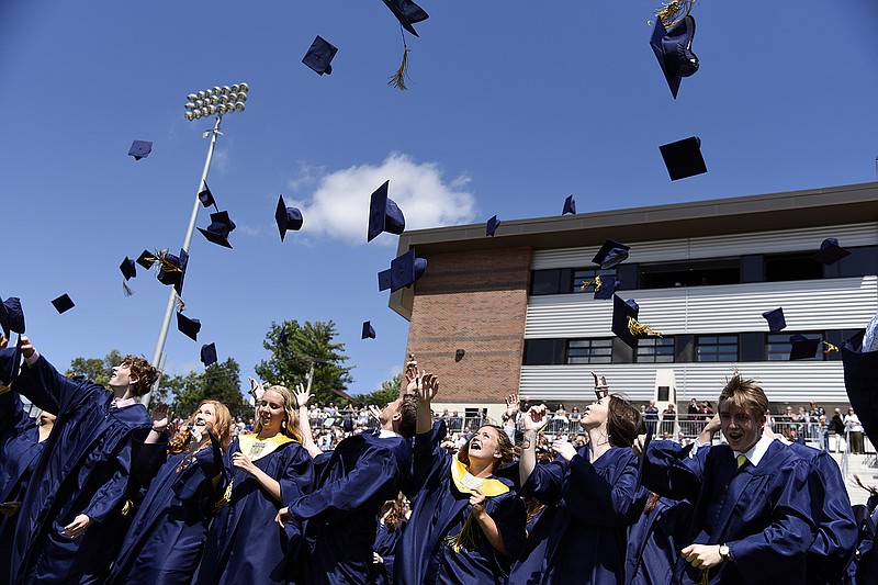 FILE: Helias Catholic High School graduates throw their caps in the air after officially graduating in May 2019 at Ray Hentges Stadium. This was the first year the commencement ceremony was held outside at the Helias Athletic Complex.