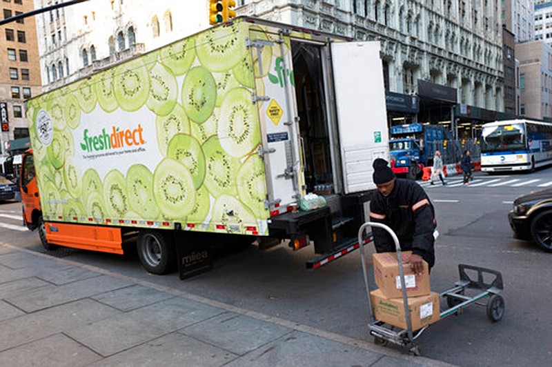 A FreshDirect driver loads boxes into his truck on Nov. 27, 2017, in New York.  Grocery delivery services are growing rapidly, but shoppers need to decide if the convenience is worth the higher cost. Big companies like Amazon and Walmart are expanding grocery delivery, as are regional players like FreshDirect.

