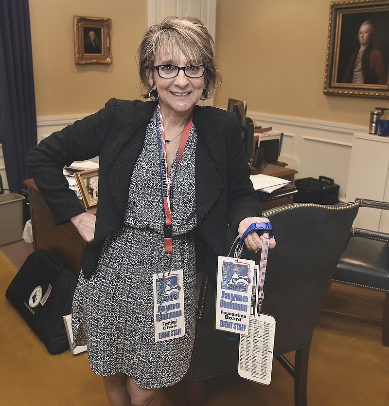 Jayne Dunkmann poses in her Jefferson Bank office with several event tags on her desk. Dunkmann is a very active volunteer in a number of Jefferson City activities, be they United Way or Salute to Jefferson City or school activities with her children.