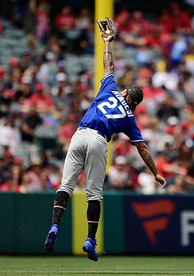 Royals shortstop Adalberto Mondesi makes a catch on a ball hit by Tommy La Stella of the Angels during the second inning of Sunday's game in Anaheim, Calif.