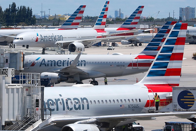 In this Wednesday, April 24, 2019, photo, American Airlines aircraft are shown parked at their gates at Miami International Airport in Miami. American Airlines is accusing its mechanics and their unions of conducting an illegal work slowdown to gain leverage in contract talks, and the airline is asking a federal judge to stop the activity. (AP Photo/Wilfredo Lee)