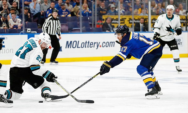 Jaden Schwartz of the Blues tries to move the puck past Joonas Donskoi of the Sharks during last Friday night's game in St. Louis.