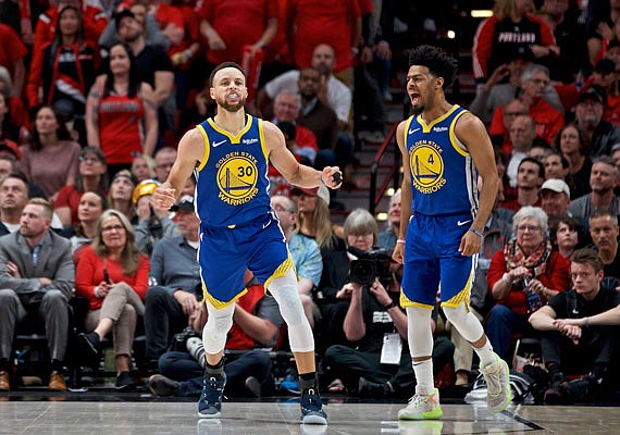 Golden State teammates Stephen Curry (left) and Quinn Cook react after Curry made a basket during Monday night's win against the Trail Blazers in Portland, Ore.