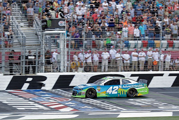 Kyle Larson takes the checkered flag to win the final segment of the NASCAR All-Star Open race at Charlotte Motor Speedway in Concord, N.C.