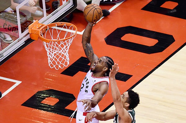 Raptors forward Kawhi Leonard scores past Bucks guard Malcolm Brogdon during the second overtime period Sunday of Game 3 of the NBA Eastern Conference finals in Toronto.