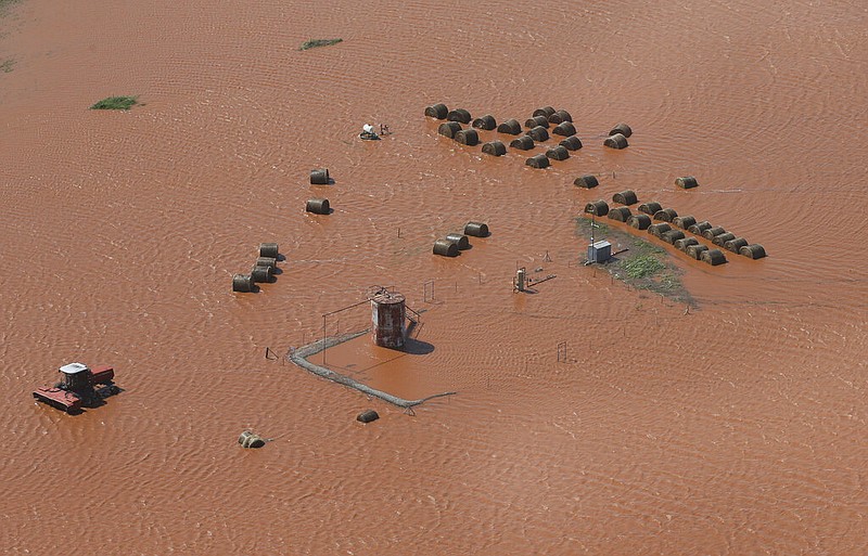 Hay bales and equipment are pictured in a flooded field, Tuesday, May 21, 2019, in Kingfisher, Okla. Flooding following heavy rains was an issue across the state. (AP Photo/Sue Ogrocki)