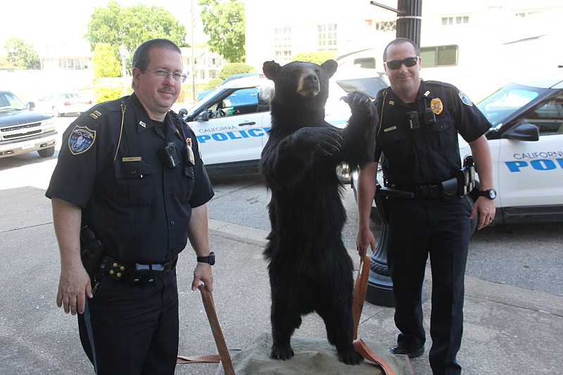 California Police Capt. Daniel Hurt and Officer Benton Fogelman pose with the newest donation to the Moniteau County Historical Society on May 16, 2019.