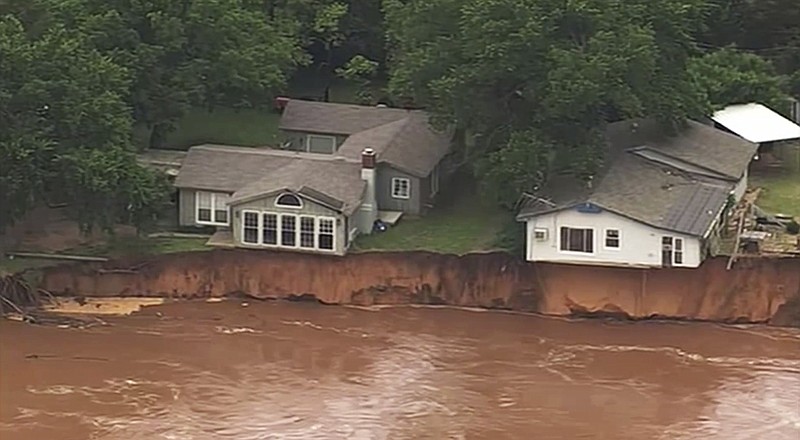 This image taken from video provided by KOCO-5 shows homes dangerously close to the Cimarron River on Wednesday, May 22, 2019 near Crescent, Oka. Waterlogged parts of the central U.S. were bracing Wednesday for more rain, following days of severe storms that have battered Iowa, Kansas, Missouri and Oklahoma.  (KOCO-5 via AP)