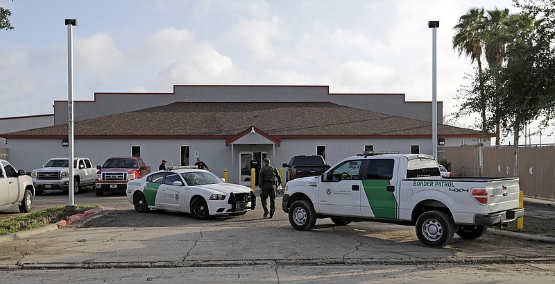 FILE - In this June 23, 2018 file photo, a U.S. Border Patrol Agent walks between vehicles outside the Central Processing Center in McAllen, Texas. U.S. border agents have temporarily closed their primary facility for processing migrants in South Texas one day after authorities say a 16-year-old died after being diagnosed with the flu at the facility. In a statement released late Tuesday, May 21, 2019, U.S. Customs and Border Protection said it would stop detaining migrants at the processing center in McAllen, Texas. CBP says "a large number" of people in custody were found Tuesday to have high fevers.  (AP Photo/David J. Phillip, File)