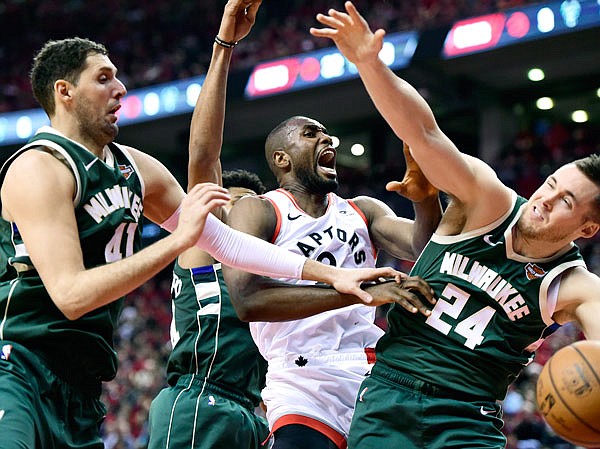 Raptors center Serge Ibaka (9) battles for the rebound against Bucks forward Nikola Mirotic (41) and guard Pat Connaughton (24) during the second half Tuesday's Game 4 of the NBA Eastern Conference finals in Toronto.