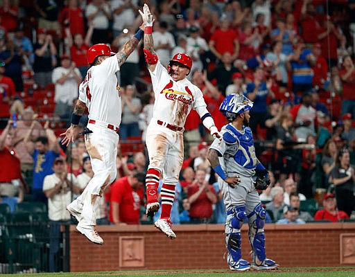 Kolten Wong (center) is congratulated by Yadier Molina after hitting a three-run home run as Royals catcher Martin Maldonado stands near the plate during the seventh inning in the second game of a Wednesday's doubleheader at Busch Stadium.