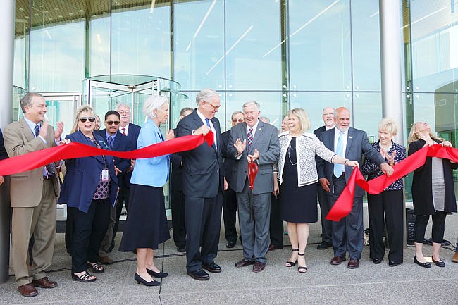 Gov. Mike Parson, center, flanked by former governor Jay Nixon (left), First Lady Teresa Parson and a bevy of other officials and dignitaries, cuts the ribbon at the Nixon Forensics Center. During his speech, Governor Parson celebrated the chance to provide a high-quality facility for the Fulton State Hospital's patients and its staff.
