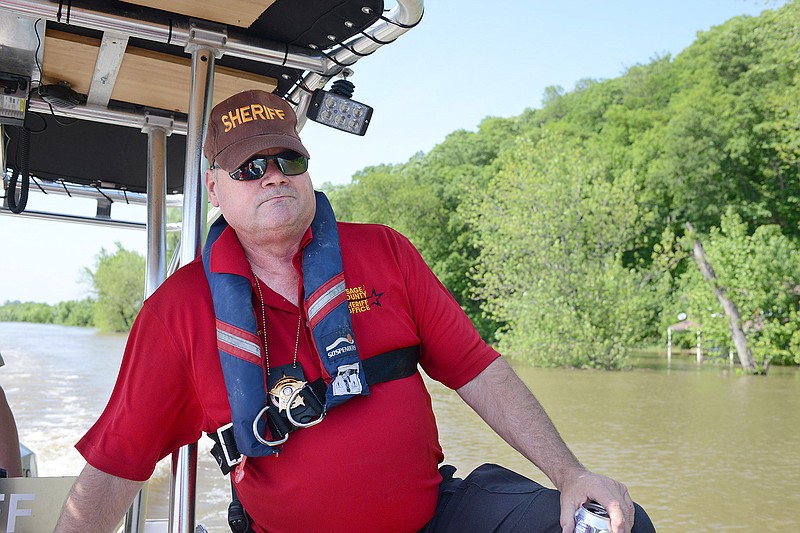 Osage County sheriff Michael Bonhom looks for flood damage Wednesday along the Osage River. Officials expect the Osage River to rise to 30 feet by today. 