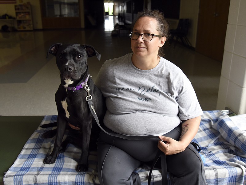 Jenna Kieser/News Tribune
Liza Loughridge sits with her labrador mix, Tilly on her cot at the Red Cross shelter on Thursday at Jefferson Middle School. Loughridge's daughter was working at the Sonic Drive-In on Ellis Blvd on Wednesday night when a tornado touched down. "I felt the pressure in my ears and the loud boom," said Loughridge. 