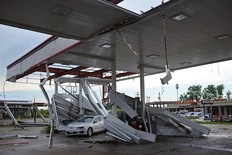 Sally Ince/ News Tribune
Metal covering rests wrapped around poles and a damaged car Thursday May 23, 2019 at a gas station along Ellis Boulevard after a tornado tore through the city Wednesday night. The National Weather Service has ruled Wednesday’s tornado as an EF-3, with peak winds reaching 160mph.